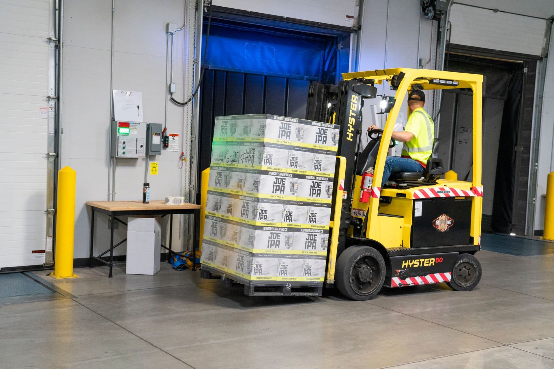 Forklift operator moving palletised goods